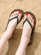 Pair of leopard print toe post flats slippers with red painted toenails