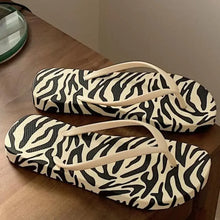 Pair of zebra-print toe post flats slippers with cream straps