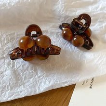 Two tortoiseshell acrylic hair claw clips with spherical accents