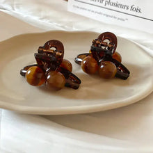Two brown tortoiseshell acrylic hair claw clips with spherical beads