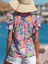 A vibrant tropical floral print blouse with ruffled short sleeves and a notched neck in bright colors