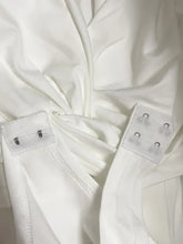 White long sleeve twist front bodysuit with elastic straps and silver metal clasps detail on fabric