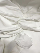 White satin long sleeve bodysuit with twist front detail and delicate stitching along the hem