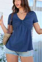 Blue short sleeve blouse featuring a twist knot front detail and soft flowing fabric for stylish comfort