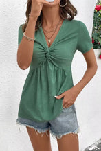 Green short sleeve blouse with a twist knot v neck and relaxed fit perfect for casual wear