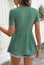 A soft green twist knot v neck short sleeve peplum blouse with relaxed fit and subtle texture