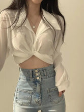 White sheer long sleeve button-up blouse with twisted front knot detail perfect for elegant occasions