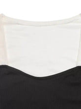 Back view of two tone long sleeve bodysuit in black ribbed fabric with white sheer mesh panel across upper back