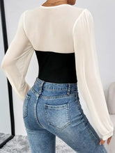 Two tone long sleeve bodysuit featuring a sheer off-white top with a black ribbed bodice for stylish layering