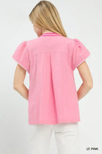 A light pink Umgee abstract applique split neck blouse with puffed sleeves and decorative neckline trim