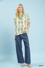 Green floral print blouse with short puffed sleeves and v-neckline featuring umgee abstract border print design