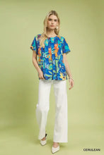 Blue abstract floral print short-sleeved umgee blouse with vibrant orange and green accents and pleated details