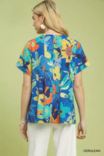 Umgee abstract floral pleated blouse featuring a vibrant blue short-sleeved top with colorful blossoms and leaves