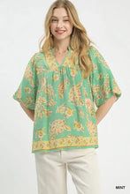 Mint-colored umgee apricot floral blouse with soft peach and gold floral print, flutter sleeves, and v-neckline