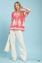 Pink short sleeve umgee boho print blouse with white embroidered patterns and v-neck split neck design