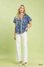 Blue short-sleeved blouse with pink trim and button front featuring botanical floral button design by umgee