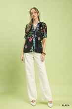 Black umgee blouse with botanical print contrast trim featuring colorful embroidered flowers and blue piping detailing