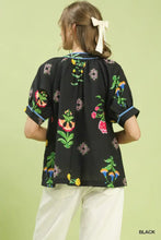 Black blouse with vibrant botanical print contrast and blue contrast trim button on cuffs and neckline by umgee