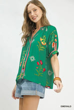 Emerald green umgee botanical print contrast trim blouse with pink trim and short flutter sleeves featuring contrast trim button
