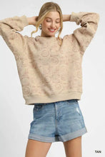 Tan oversized umgee sweatshirt featuring a subtle repeating coin stamp print pattern across the fabric