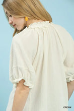 Cream-colored umgee cotton gauze ruffle top with lightweight textured fabric, ruffled neckline, and puffed sleeves