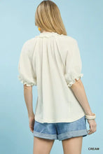 Cream-colored umgee cotton gauze ruffle top with short puffed sleeves and ruffled neckline made of cotton gauze fabric