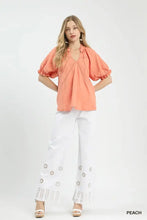 Peach-colored umgee cotton gauze ruffle top with puffed sleeves and delicate embroidered neckline