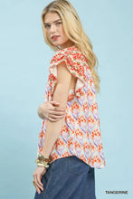 A woman wears a tangerine umgee double frill blouse with floral pattern and double frill sleeves