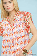 Women’s short-sleeved umgee double frill blouse with vibrant orange pink purple floral pattern and v-neckline on white background