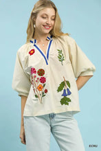 Cream-colored Umgee embroidered floral v-neck blouse featuring vibrant red, pink, orange, green, and blue embroidery