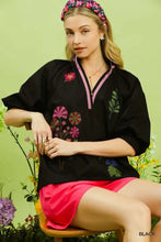 Black umgee embroidered floral v-neck blouse features pink and green floral accents on lightweight fabric