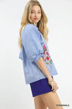 Light blue umgee embroidered floral v-neck blouse with vibrant floral embroidery on the sleeve
