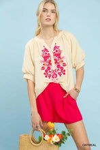 Cream-colored Umgee embroidered puff sleeve blouse with vibrant pink and red floral embroidery across the front