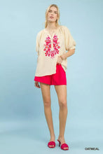 Beige embroidered puff sleeve blouse with vibrant pink floral design and loose short sleeves by umgee