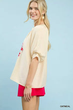 Cream-colored umgee embroidered puff sleeve blouse with loose fit and red floral embroidery on the side