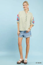 Off-white and green striped Umgee embroidered ruffle trim blouse with colorful floral embroidery on the sleeves