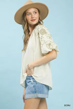 Cream-colored umgee embroidered blouse features delicate floral embroidery on the sleeves and a v-neck boho design