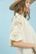 Off-white umgee embroidered blouse features delicate olive-green floral embroidery on the sleeves with a v-neck design