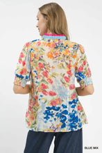 Umgee floral contrast pleat neck top with vibrant pink orange blue green blossoms on a light cream blouse with puffed sleeves