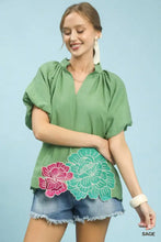 Sage green umgee floral embroidered hem blouse with puff sleeves and pink and teal floral appliqués