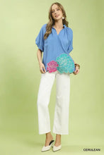Blue Umgee blouse featuring vibrant pink and teal floral embroidered hem with intricate floral appliqués at the edge