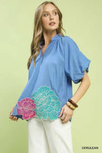 Umgee floral embroidered hem blouse in cerulean with vibrant pink and teal floral embroidered detailing on front hem