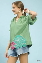 Sage green umgee floral embroidered hem blouse with pink and teal flower appliqués and delicate embroidery