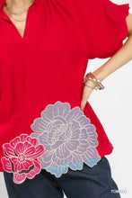 Vibrant red umgee blouse with intricate pink and lavender floral embroidered hem detailing for elegant wear