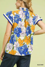 Umgee floral print blouse in vibrant blue and orange with contrast trim, high neckline, and short flutter sleeves