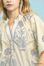 Cream-colored umgee floral print v neck blouse with black botanical embroidery and striped trim