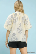 Cream-colored umgee floral print blouse with black botanical embroidery and puffy short sleeves in floral print design