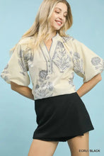Cream-colored umgee floral print v neck blouse with black botanical embroidery for stylish casual wear