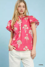 A vibrant coral Umgee split neck blouse featuring a floral ruffle sleeve pattern and ruffled short sleeves
