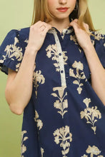 Navy blue umgee floral ruffle sleeve top with cream floral embroidery and a split neck design with ruffled short sleeves